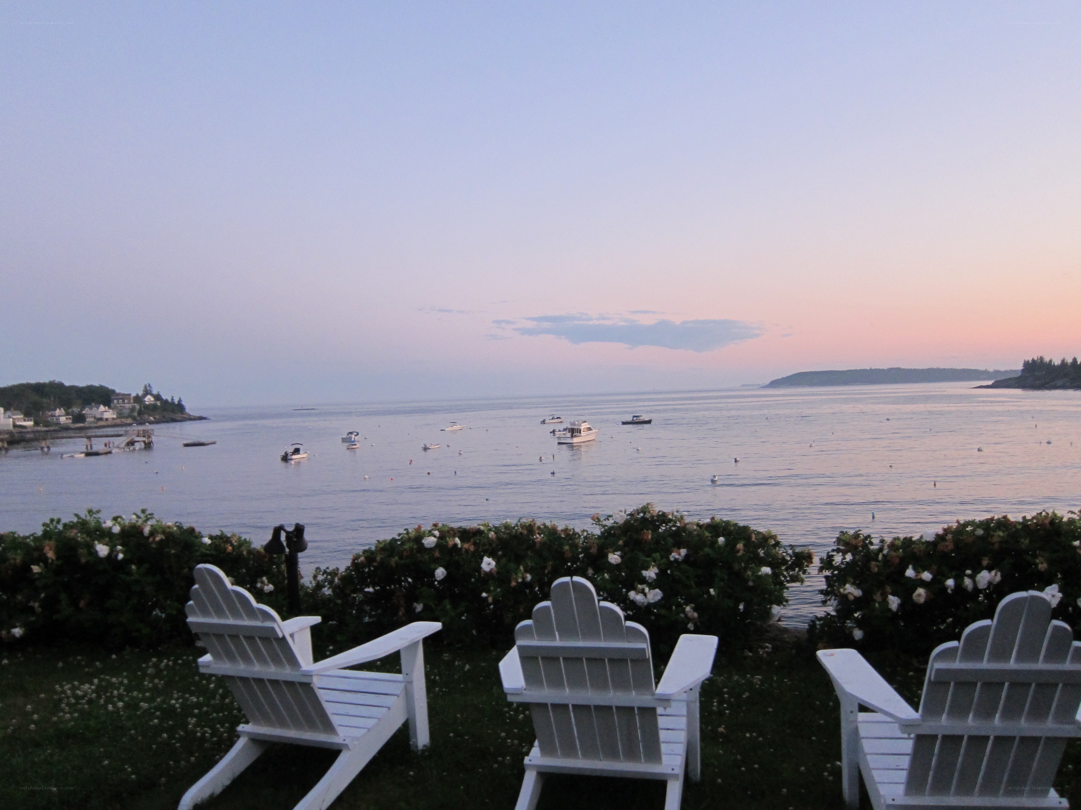 Chairs overlooking a harbor at dusk