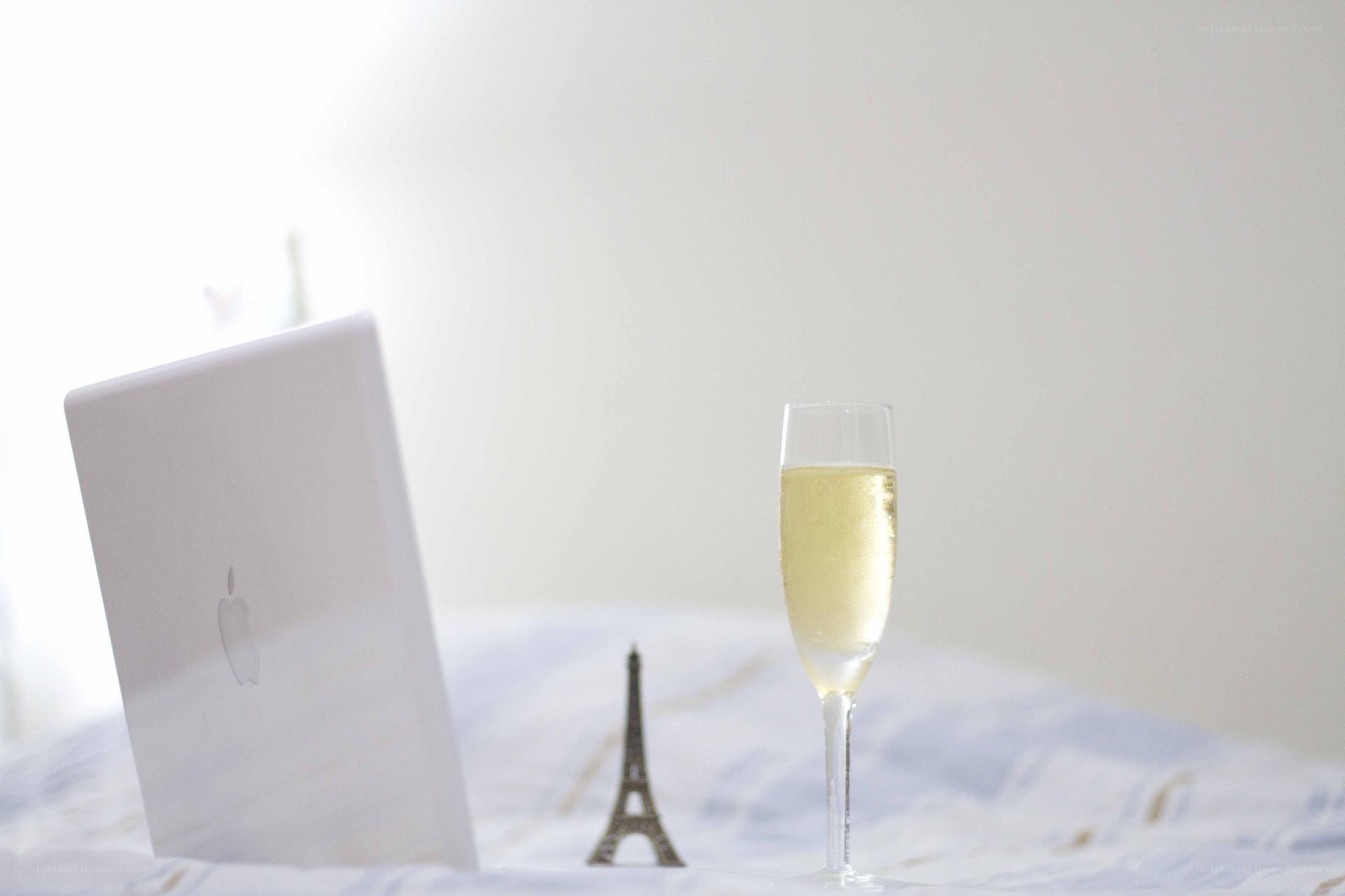 Champagne and laptop on bed