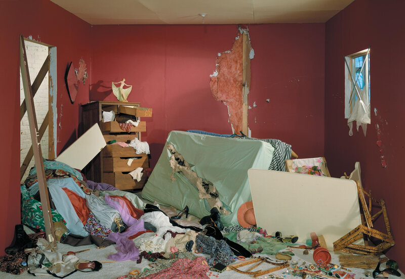 chaotic bedroom with damaged walls