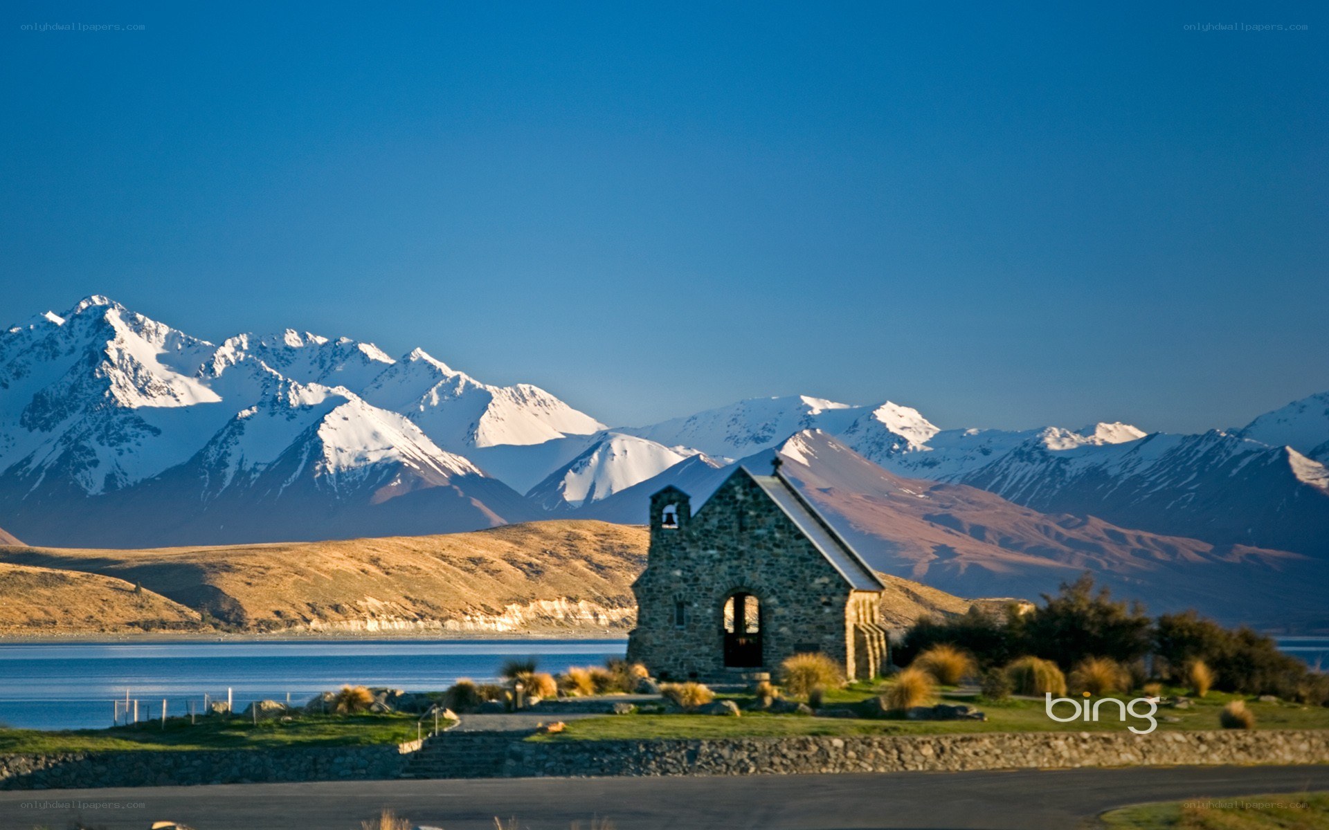 Chapel by a lake with mountains