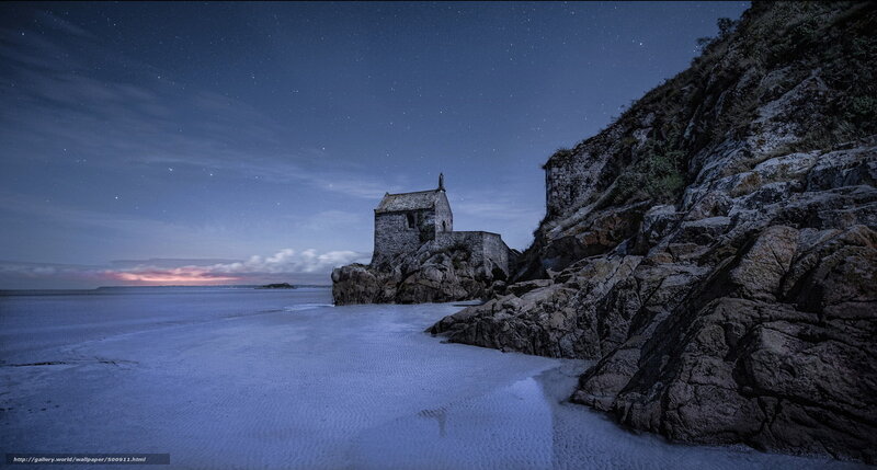 Chapel on a rocky beach at night