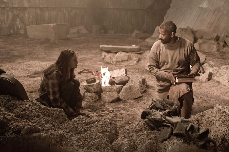 Characters by a fire in ruins