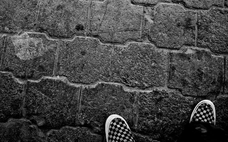 Checkered Shoes on Pavement — Black, Neutral, Photograph