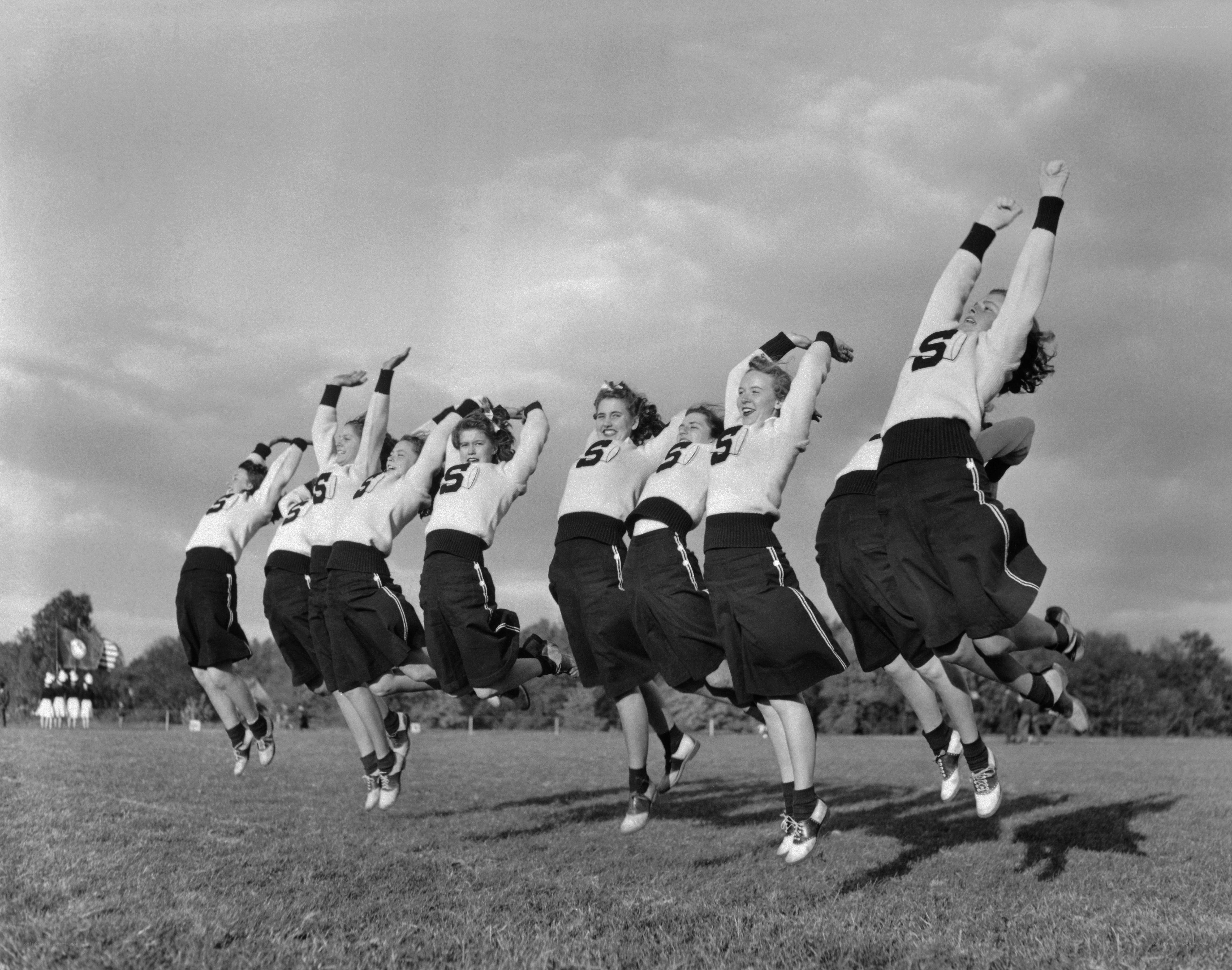 Cheerleaders jumping in unison