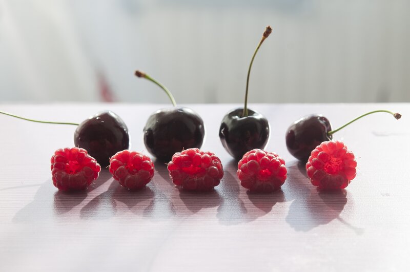 cherries and raspberries on table