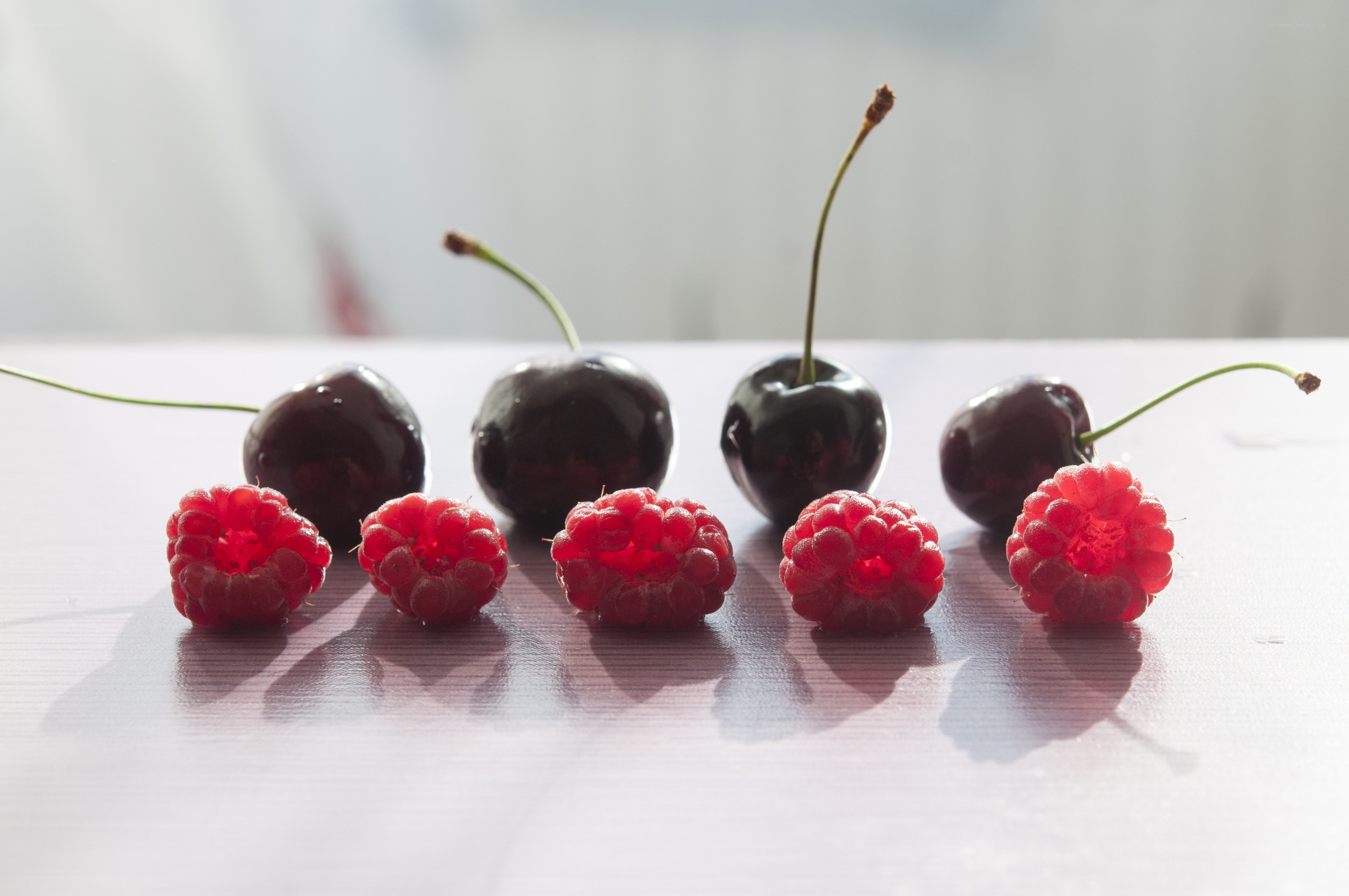 cherries and raspberries on table