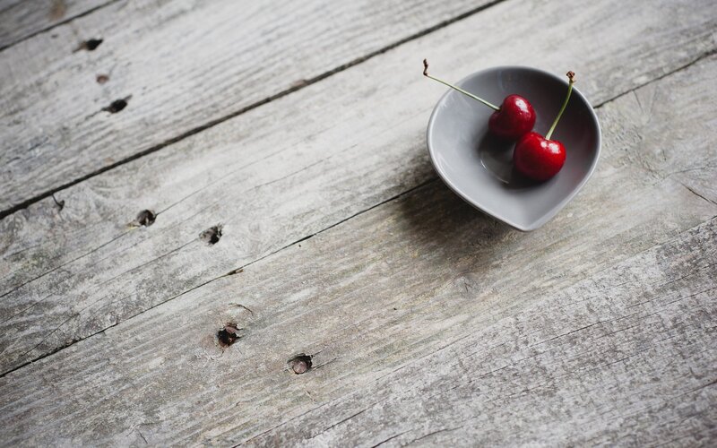 Cherries in a bowl on wood