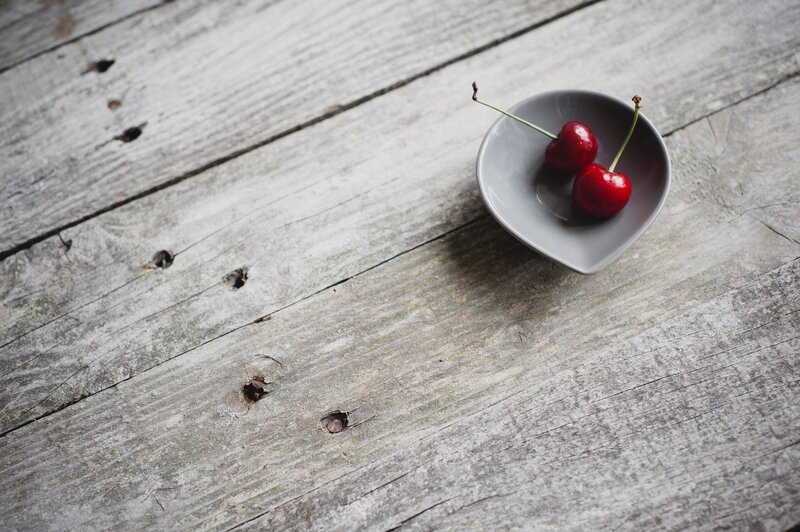 cherries in a bowl on wood