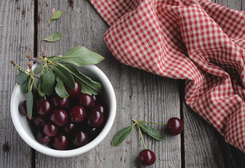Cherries in a bowl on wood