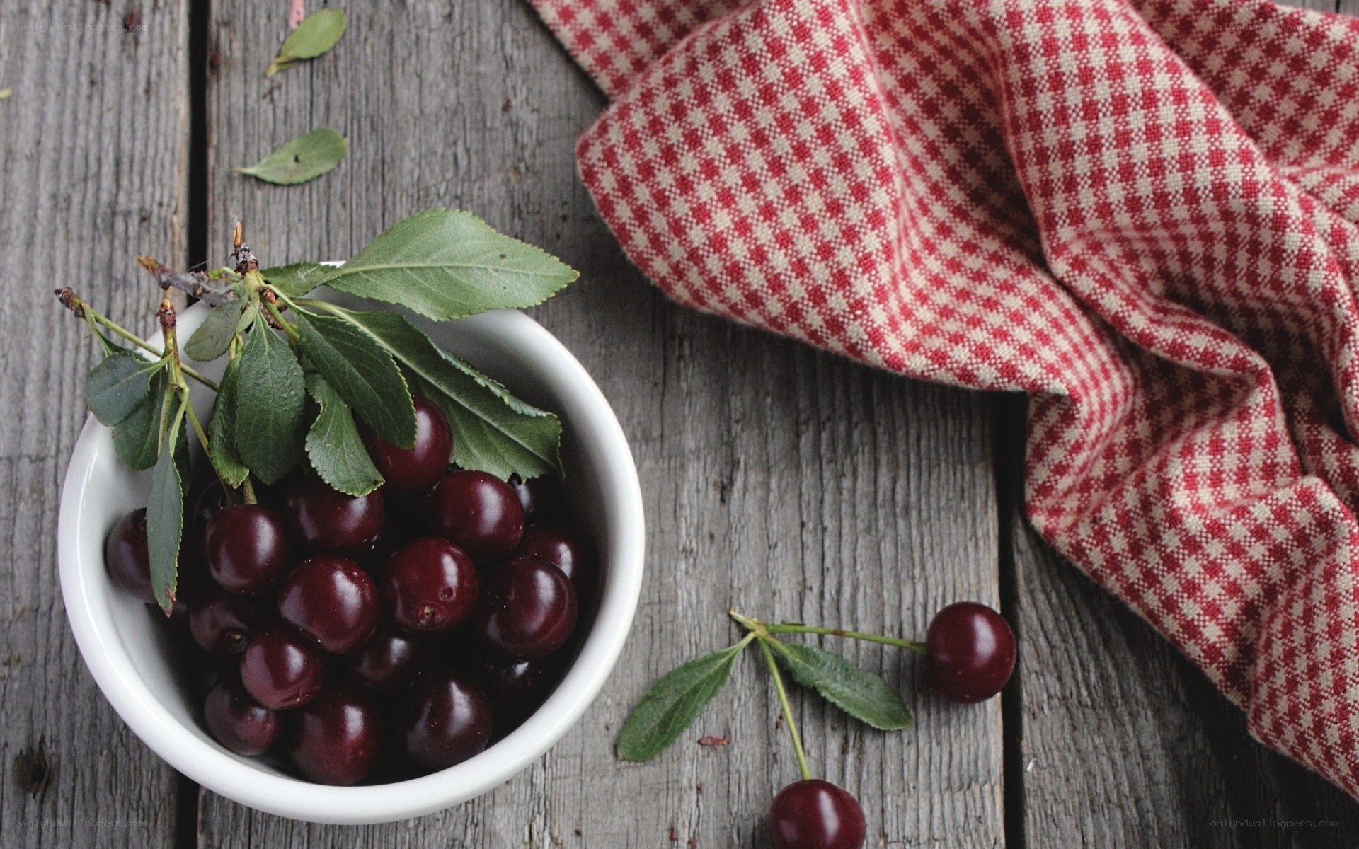 Cherries in a bowl on wood