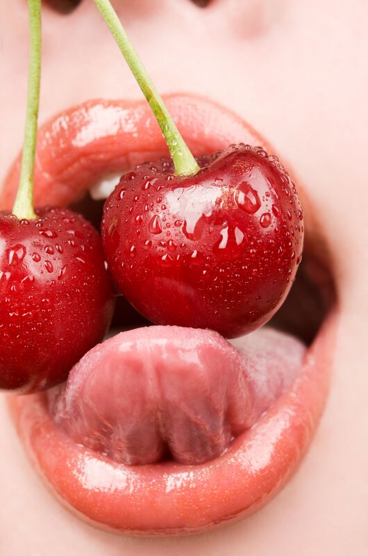 Cherries in a person's mouth
