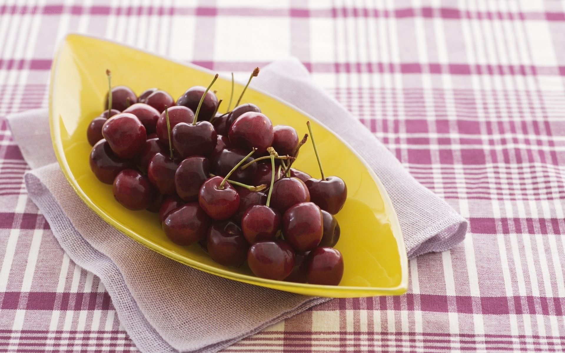 Cherries on a yellow plate