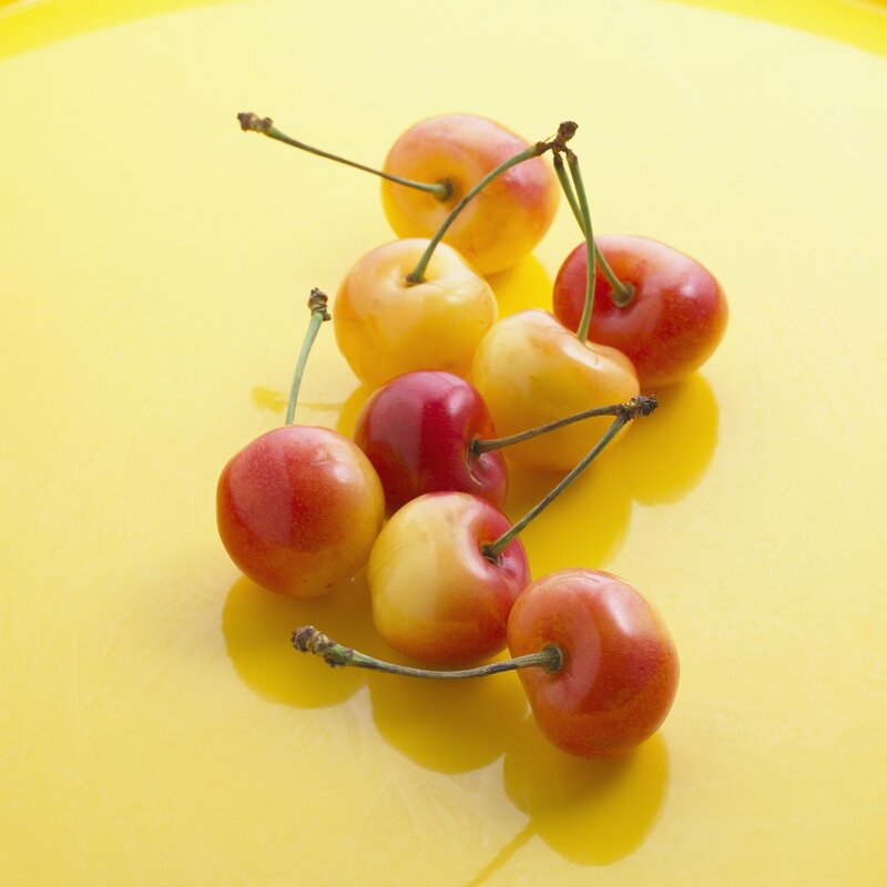 Cherries on a yellow surface