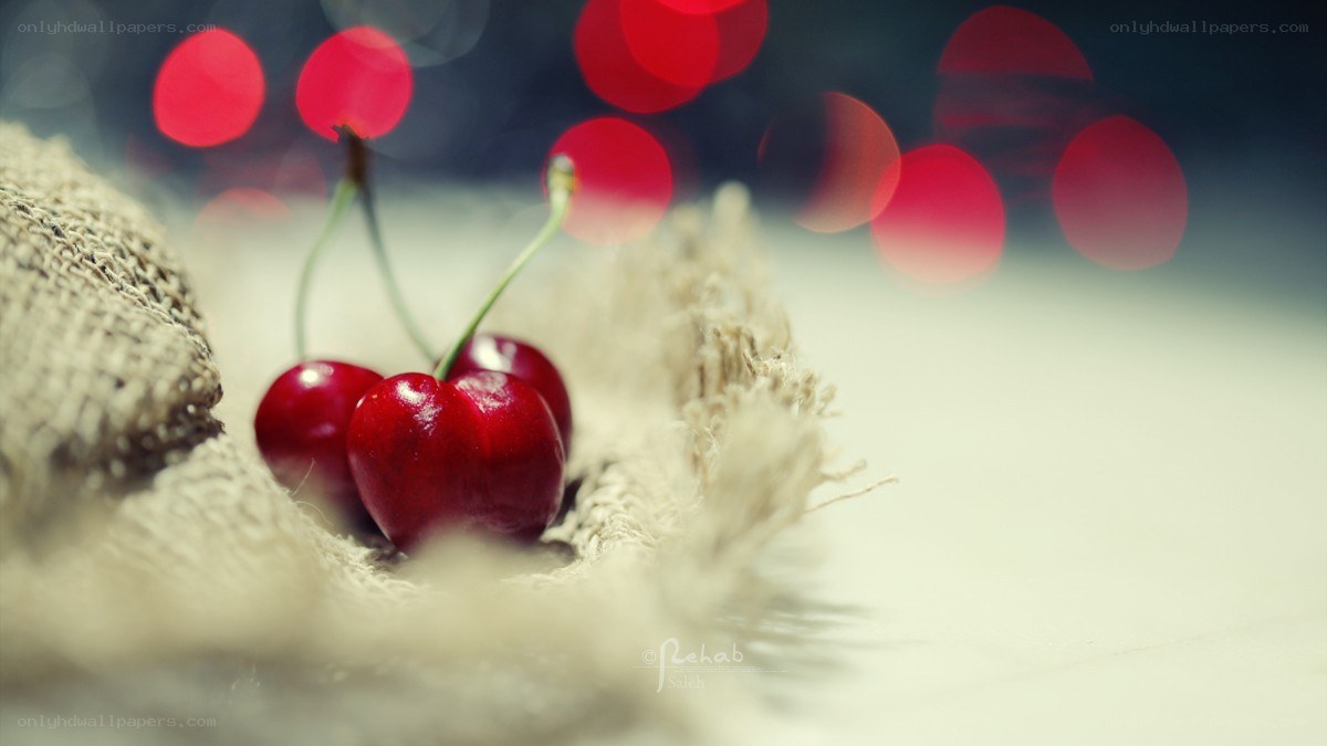 cherries on burlap with bokeh