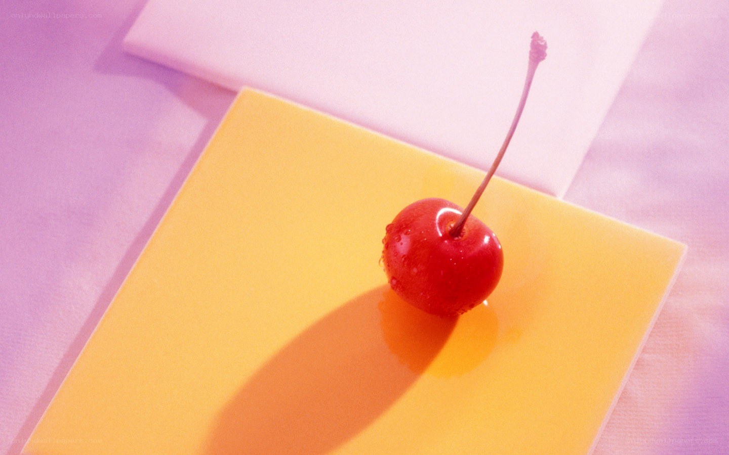 Cherry on a yellow surface