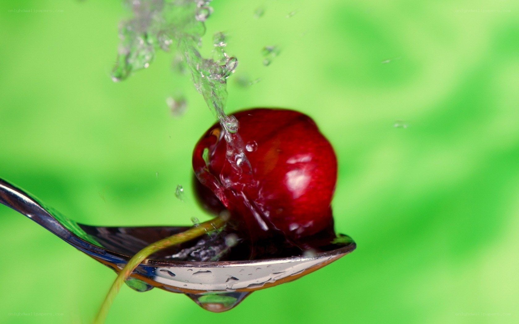 Cherry on spoon with water splash