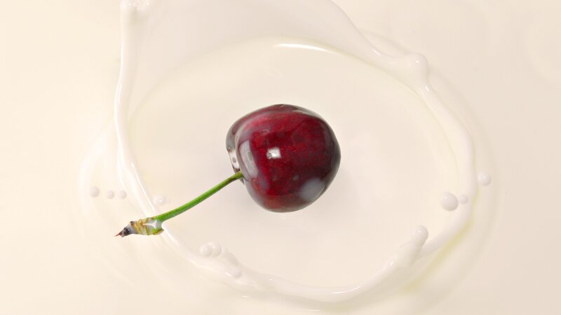 cherry splashing in milk