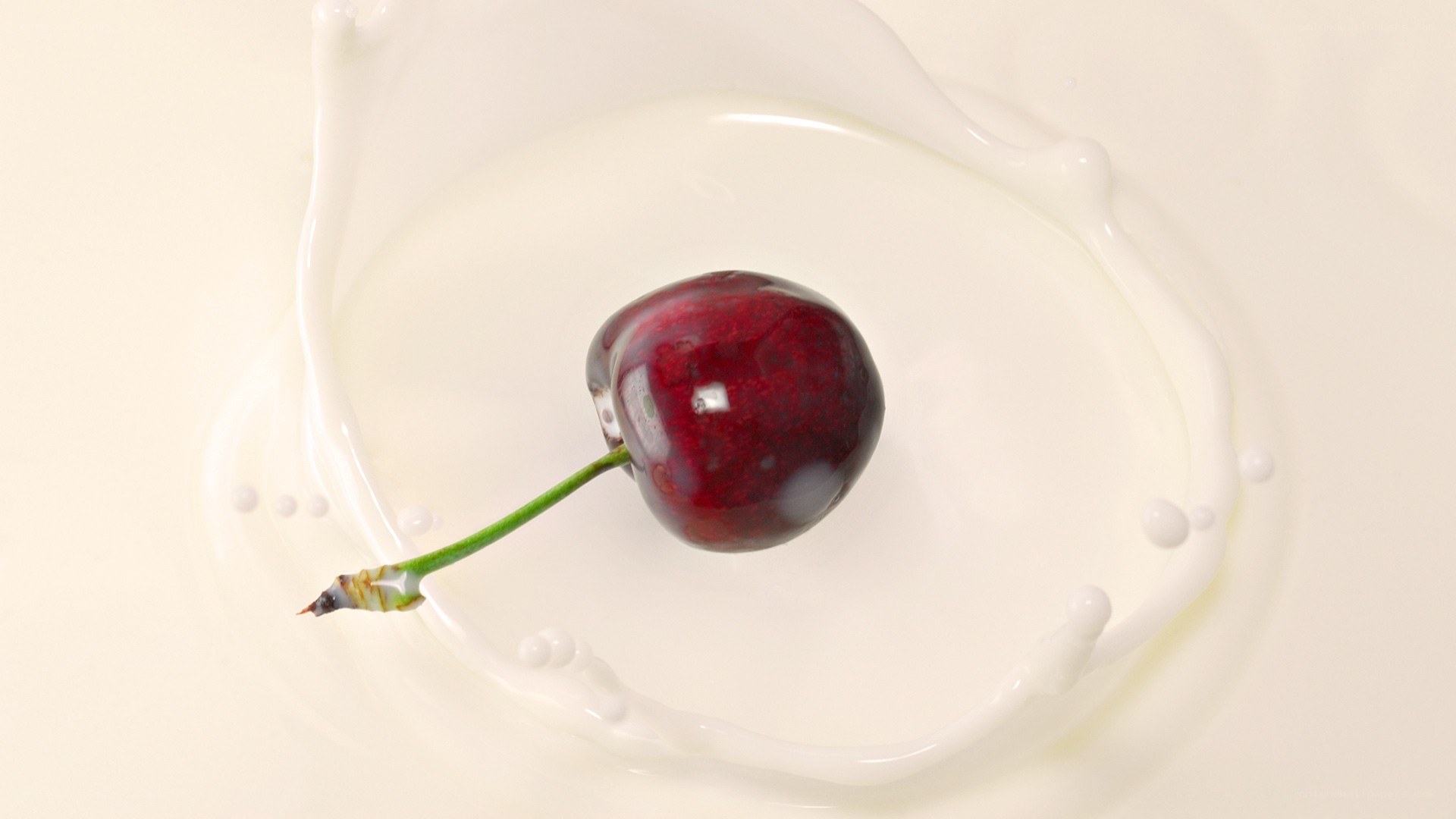 cherry splashing in milk
