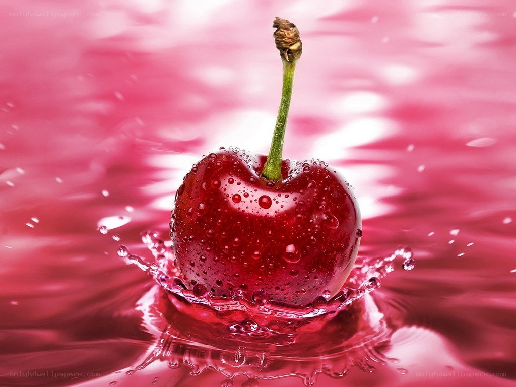 Cherry splashing in red liquid