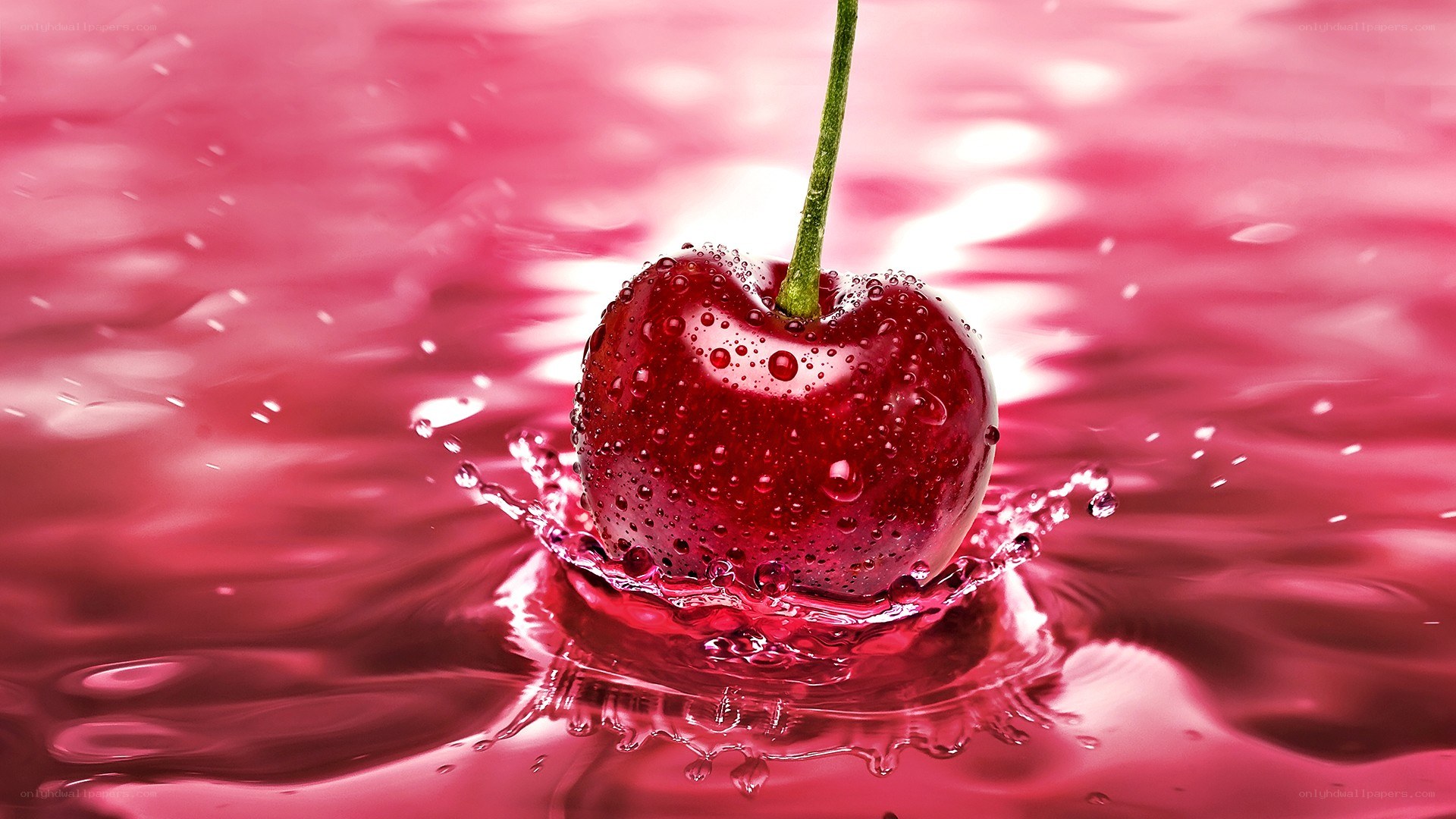 Cherry splashing in red liquid