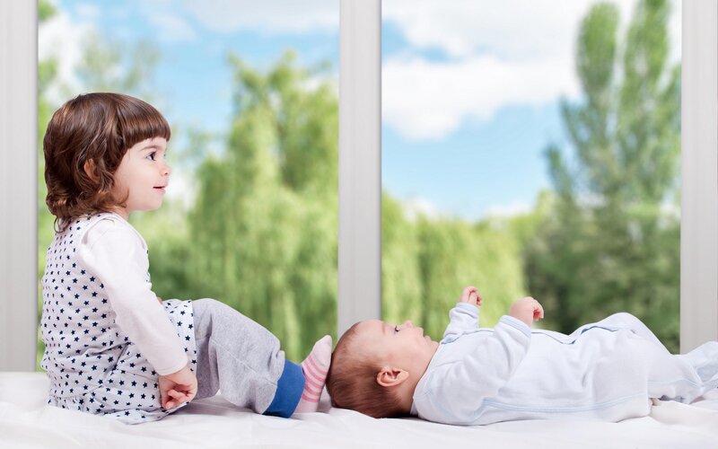 Child and Baby on Bed