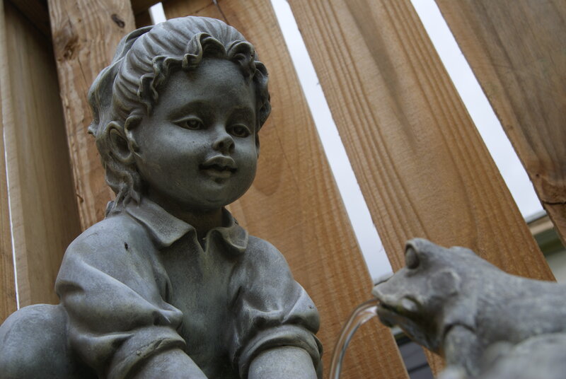 child and frog statue