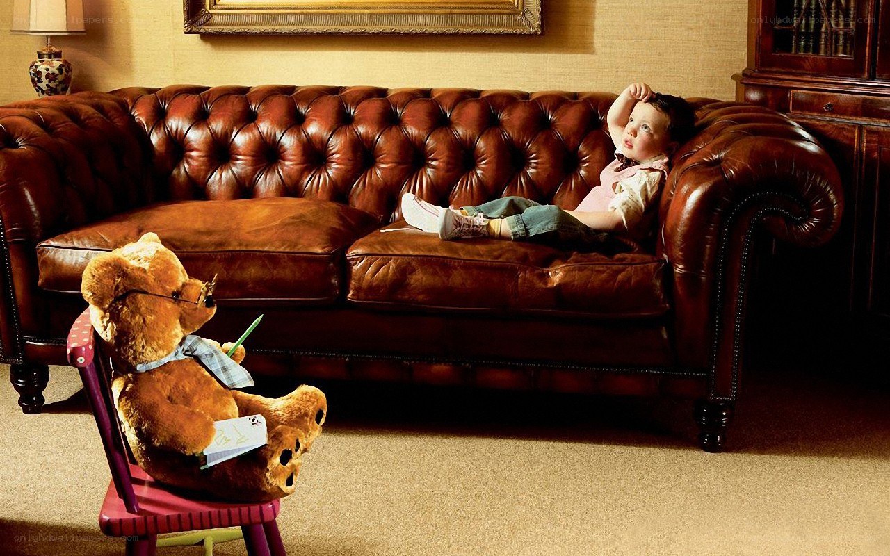 Child and teddy bear on a sofa