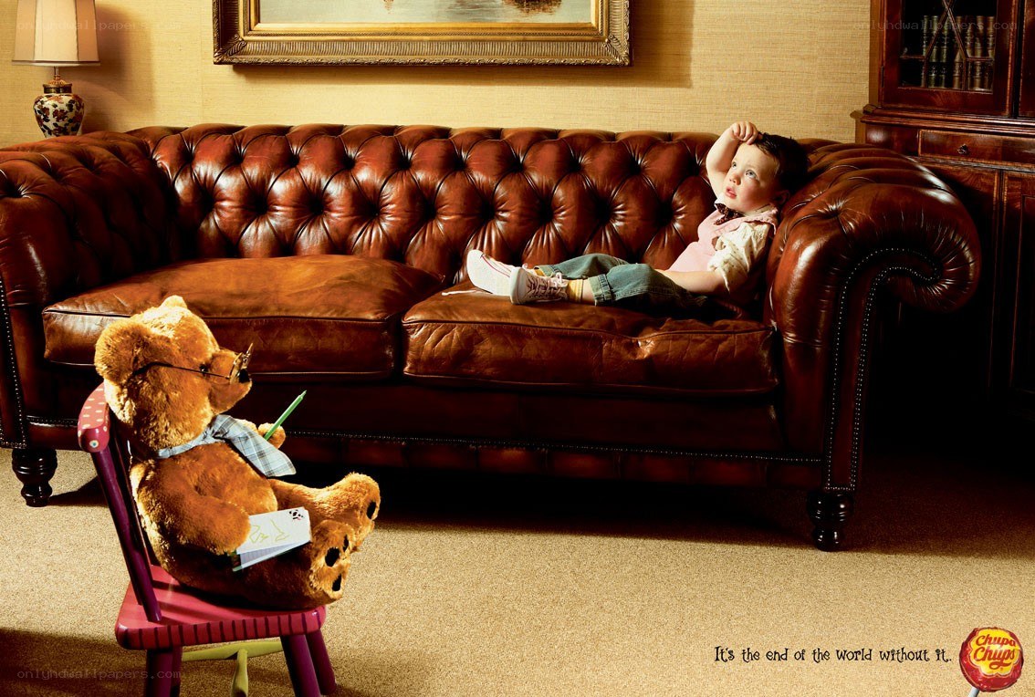 child and teddy bear on sofa