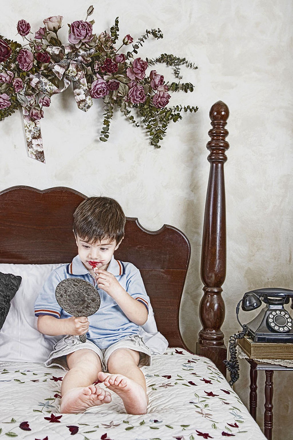child applying lipstick in bed