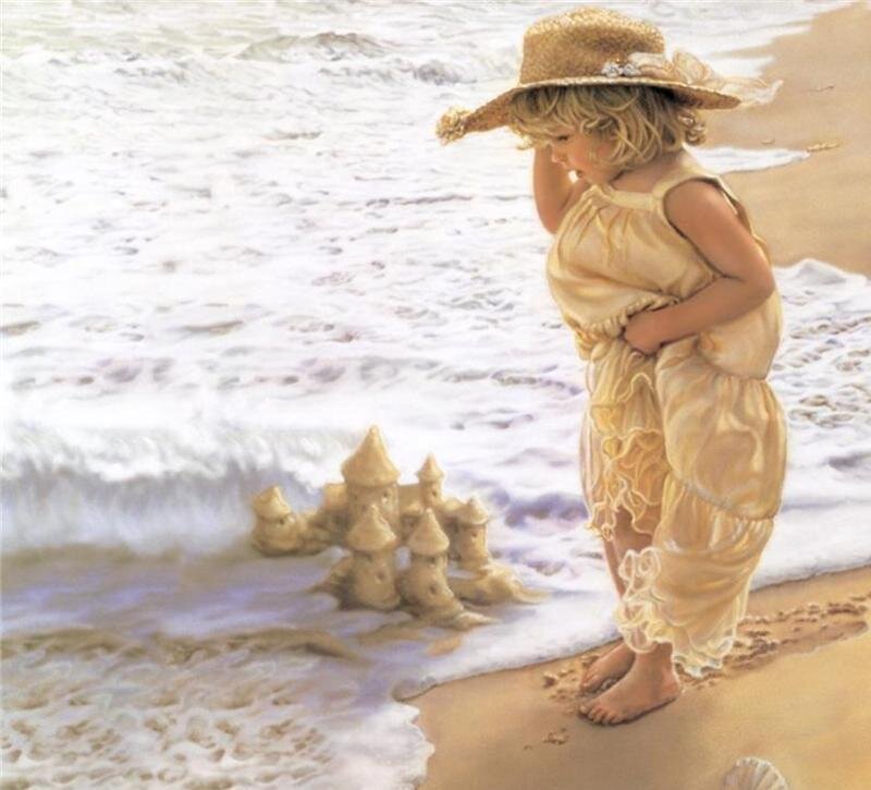 child at beach with sandcastle
