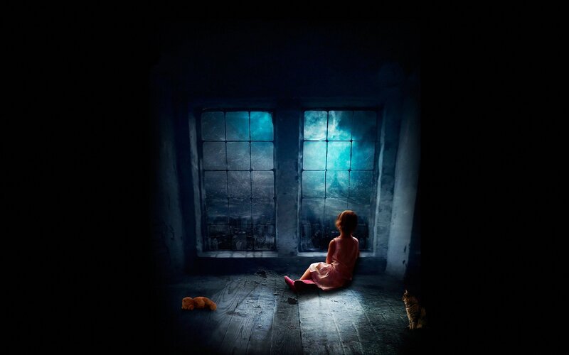 child at window in dark room
