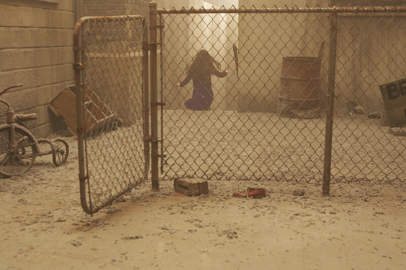 Child behind a chain-link fence
