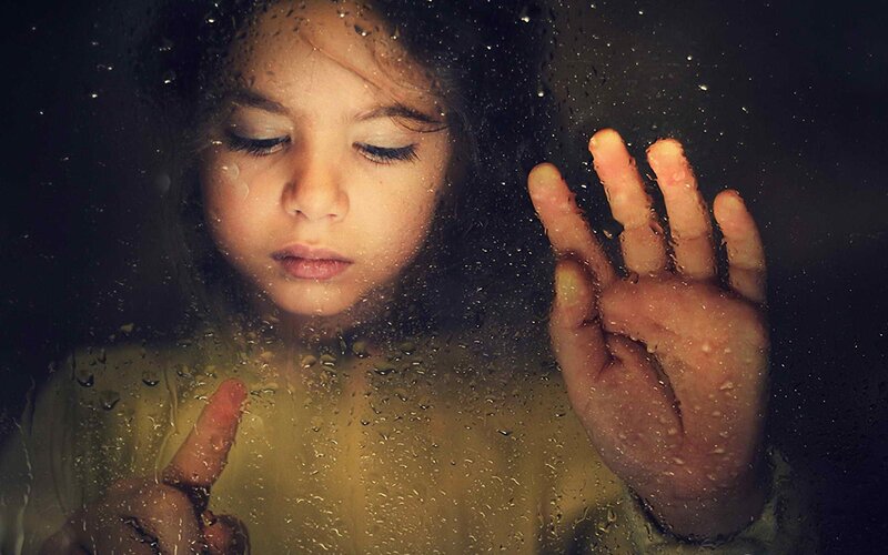 child behind a wet window