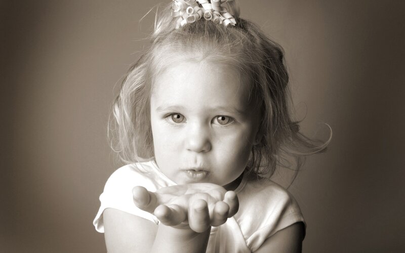 child blowing a kiss