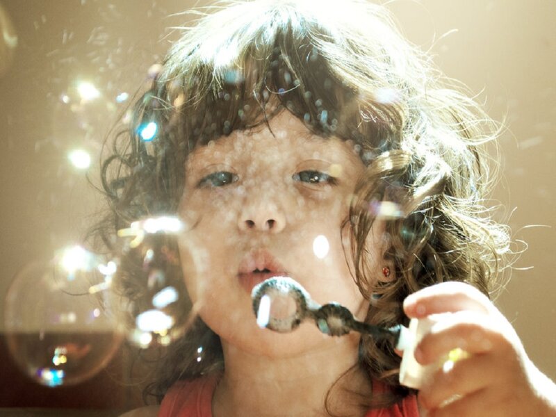 Child Blowing Bubbles — Brown, Playful
