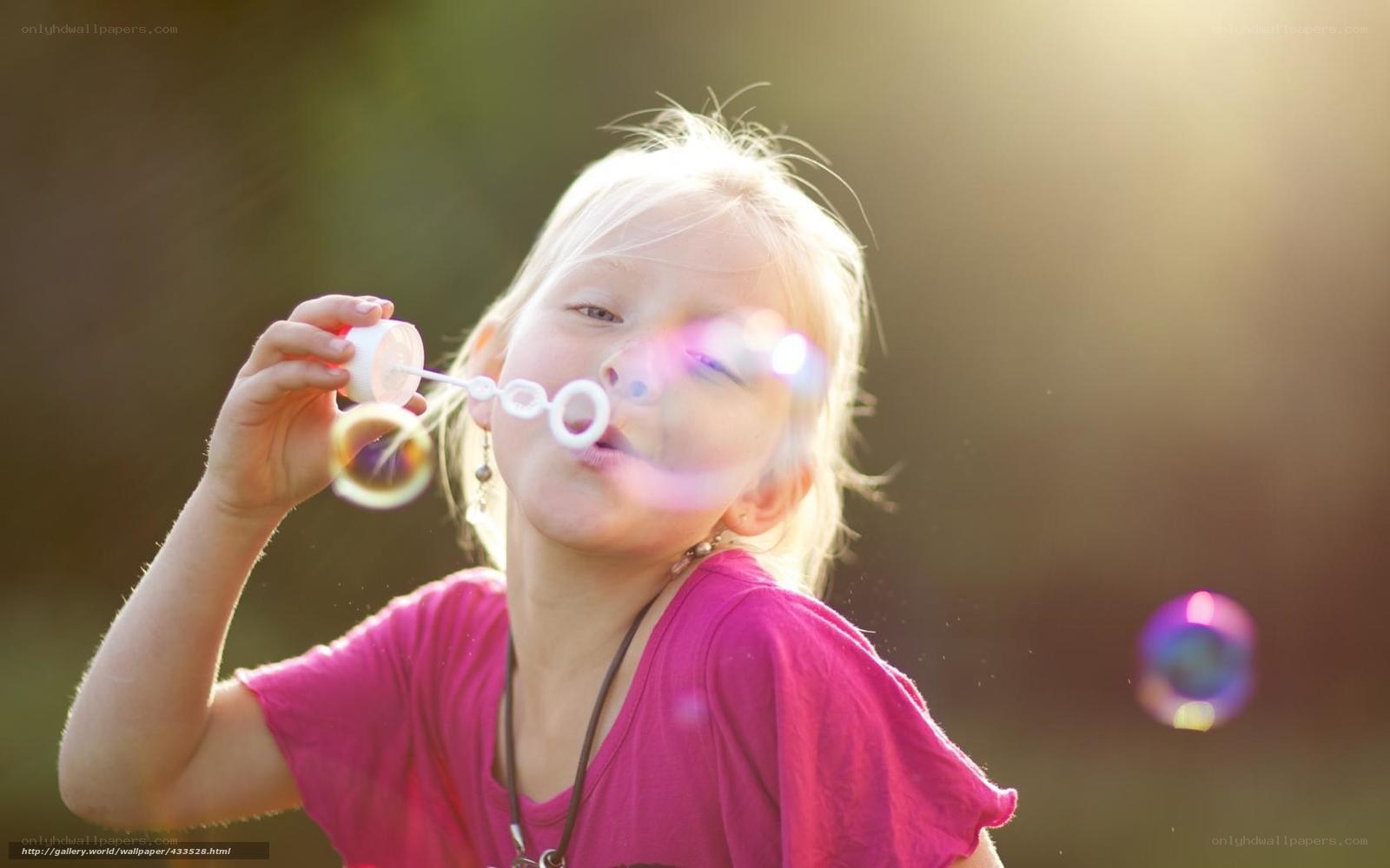 child blowing bubbles outdoors