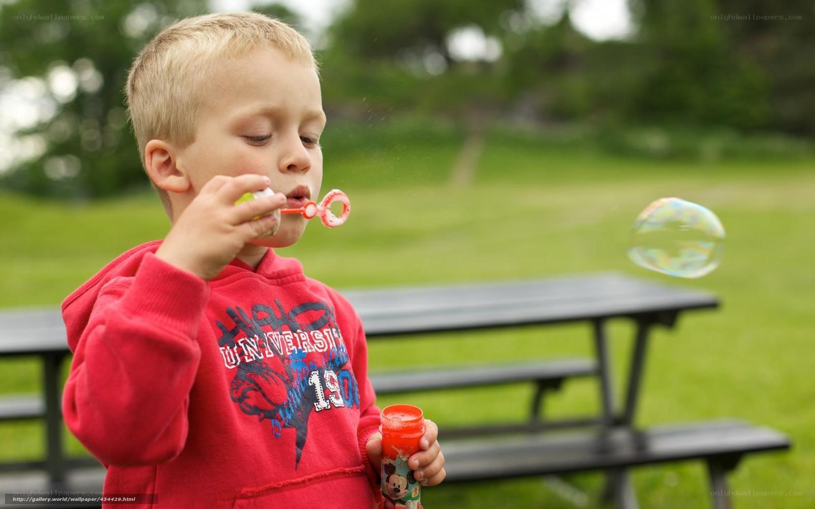 child blowing bubbles outdoors