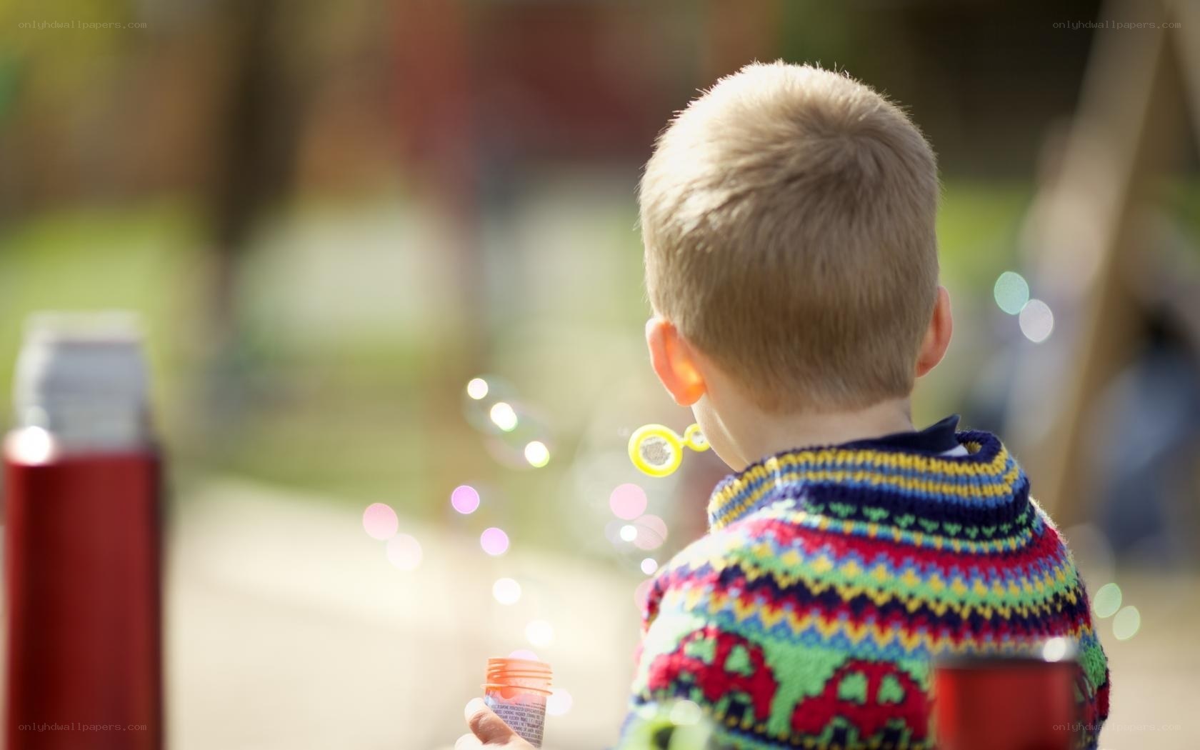 child blowing bubbles outdoors