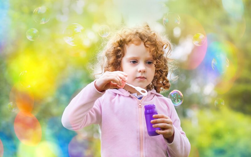Child Blowing Bubbles — Pink, Playful, Afternoon