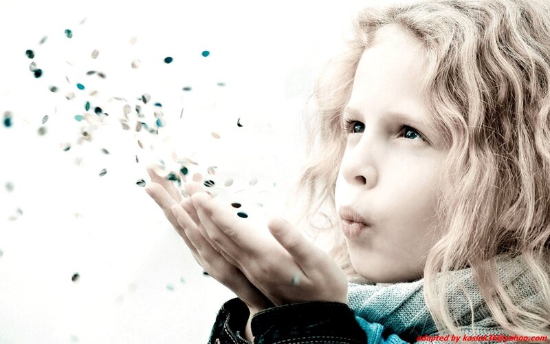 child blowing confetti