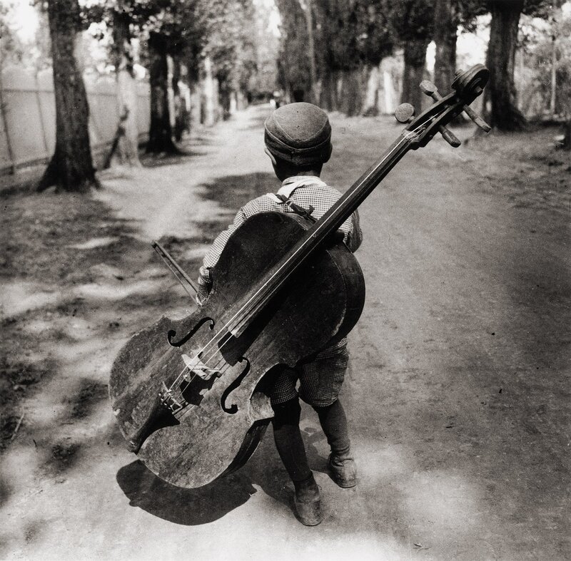 Child carrying a cello