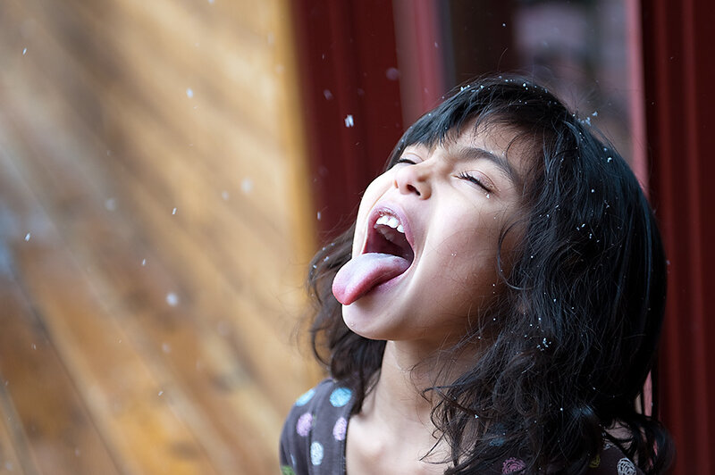 child catching snow on tongue