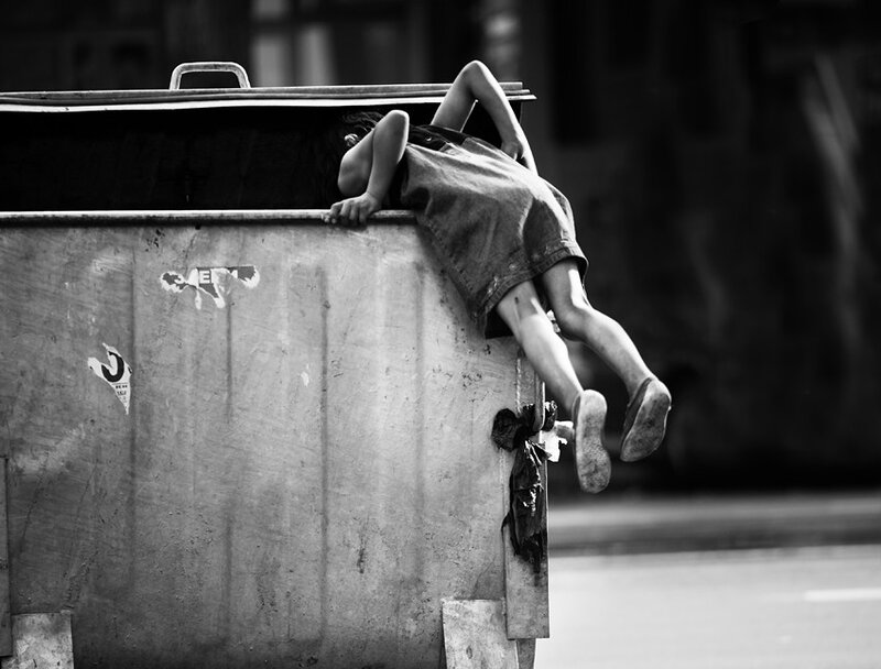 Child climbing on a dumpster