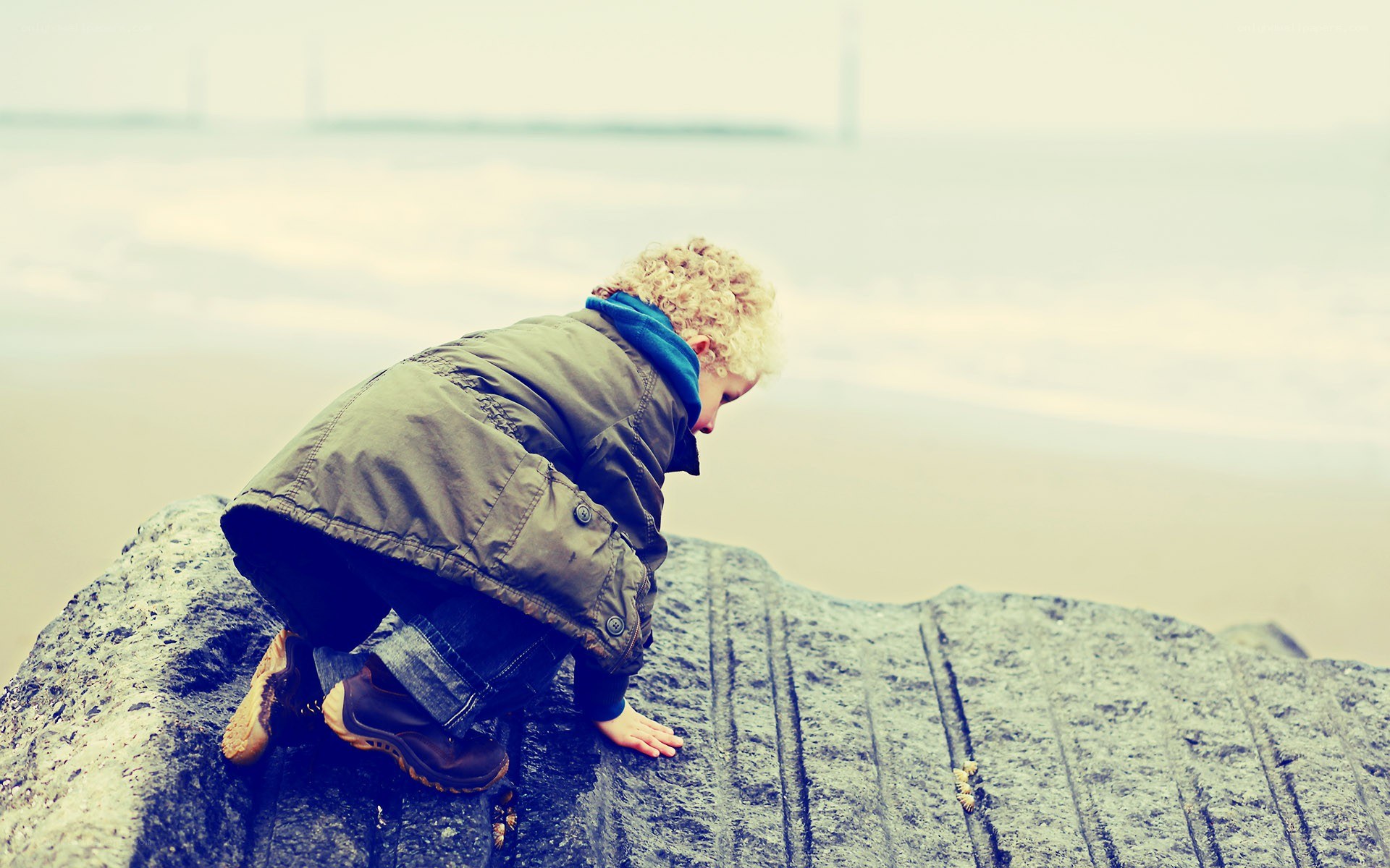 child climbing on a rock