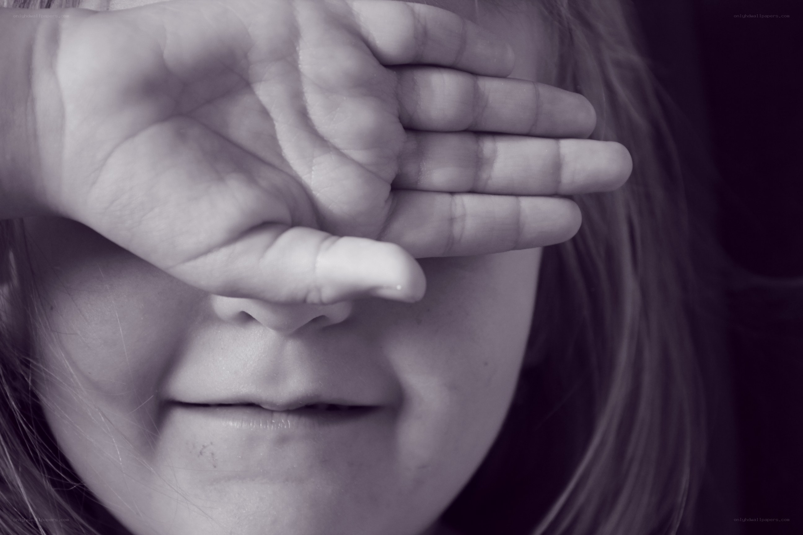 child covering eyes with hand