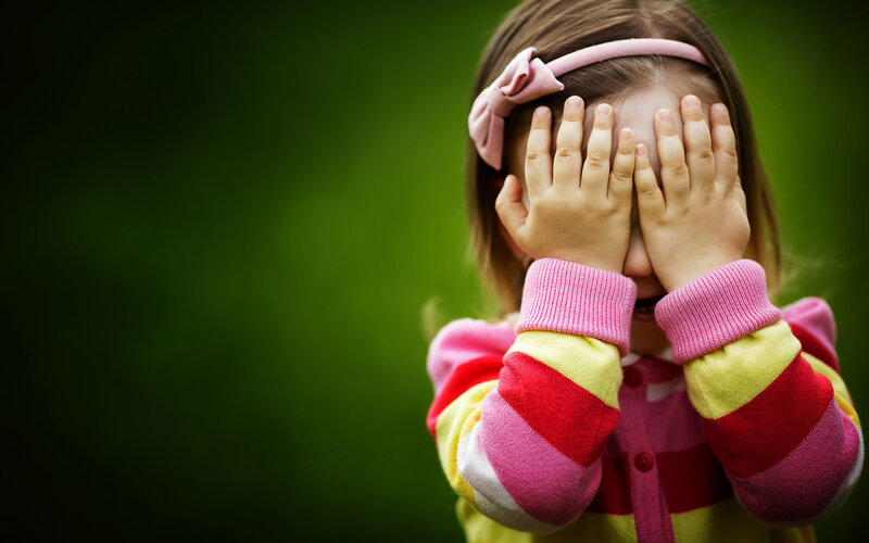 Child Covering Face — Green