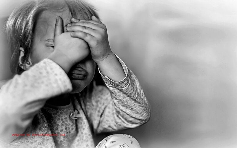 child covering face in distress