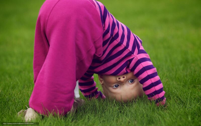 child doing handstand on grass