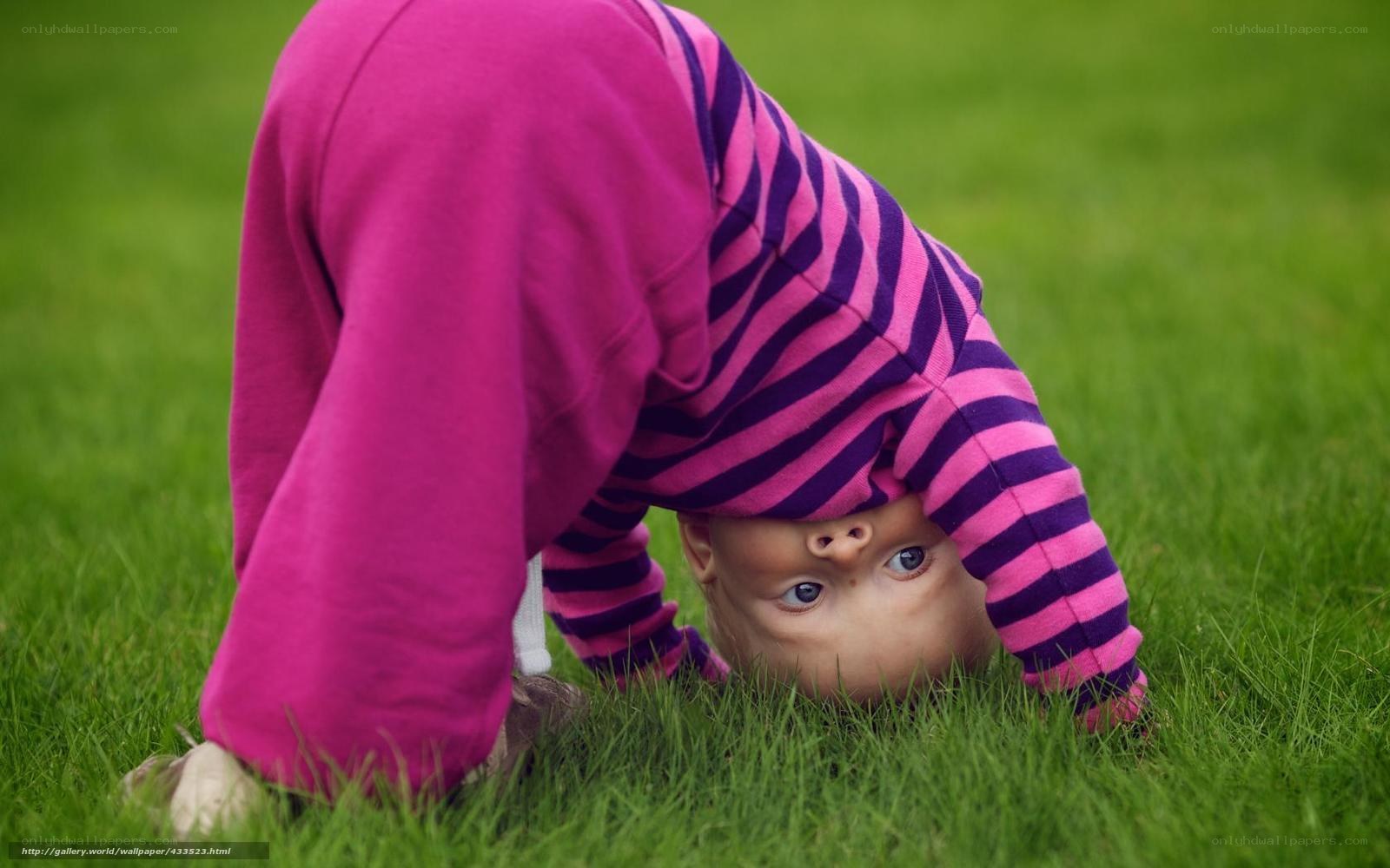 child doing handstand on grass