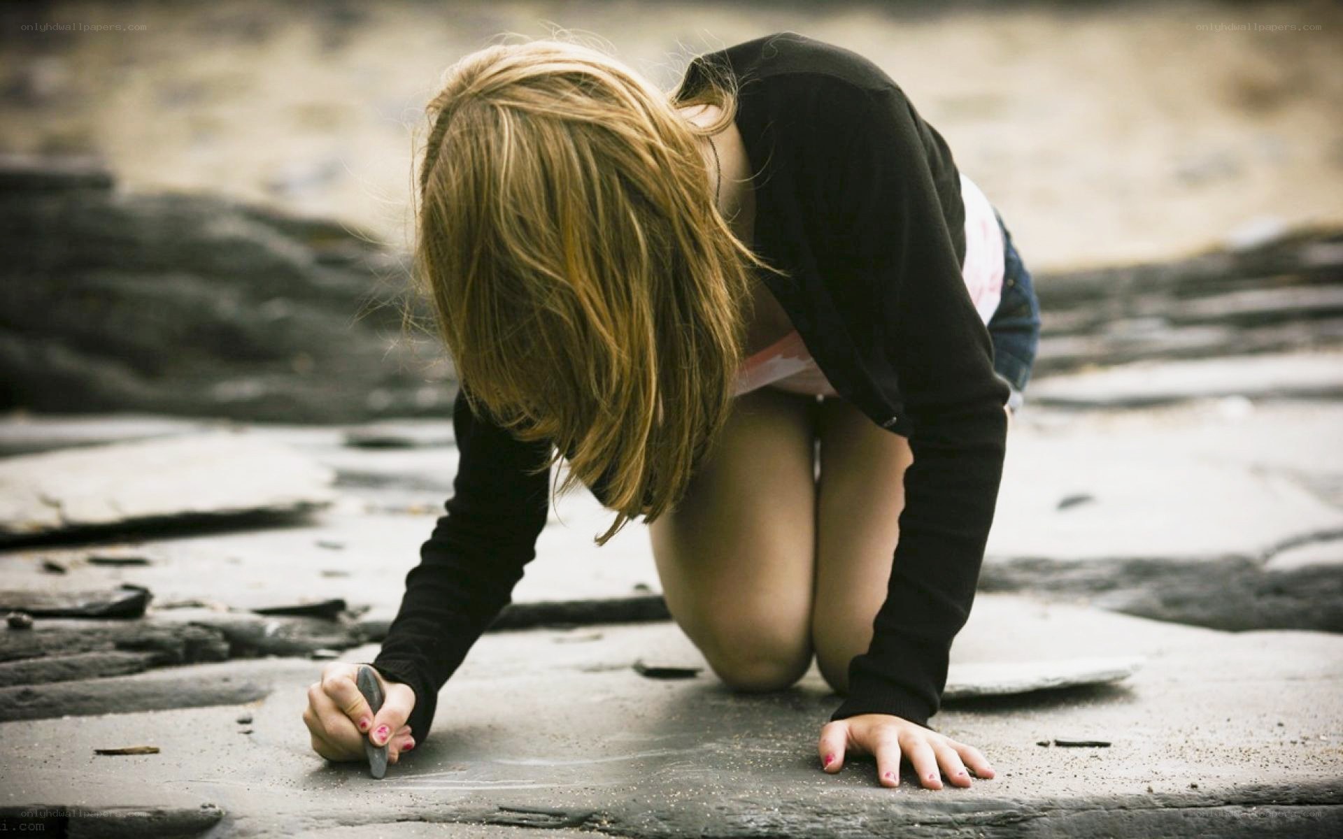 child drawing on stone